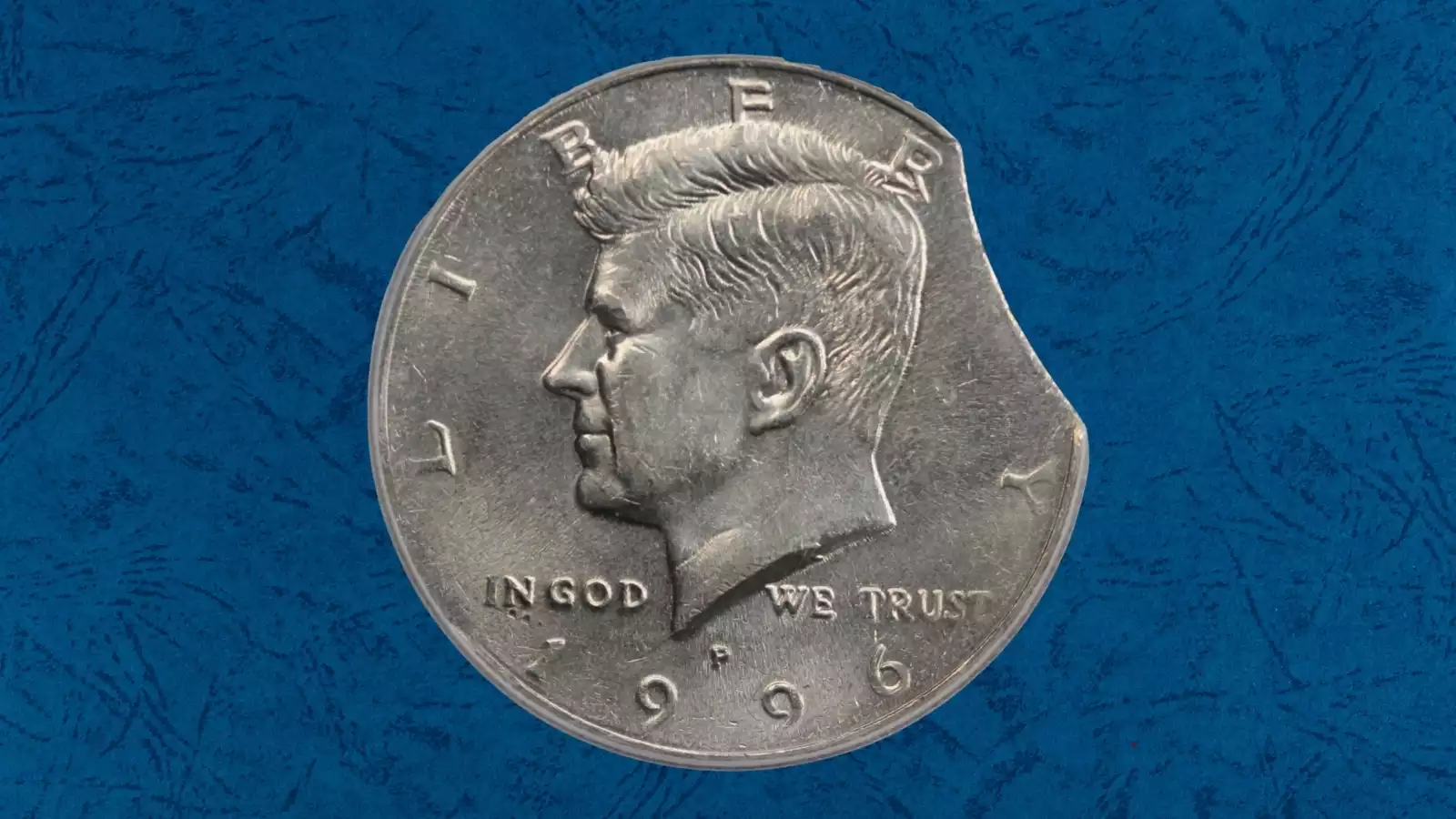 1996 Kennedy half dollar clipped planchet error with smooth curved section missing from the rim